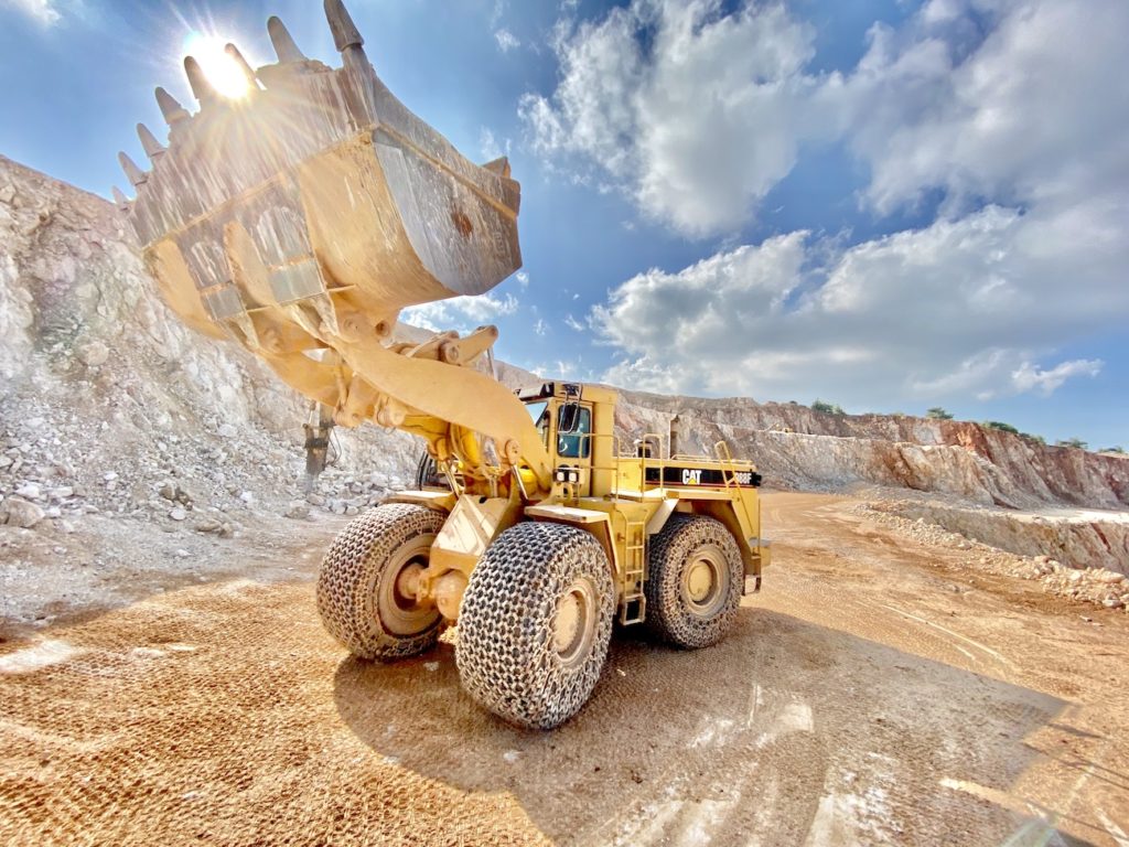 excavator in quarry and clouds
